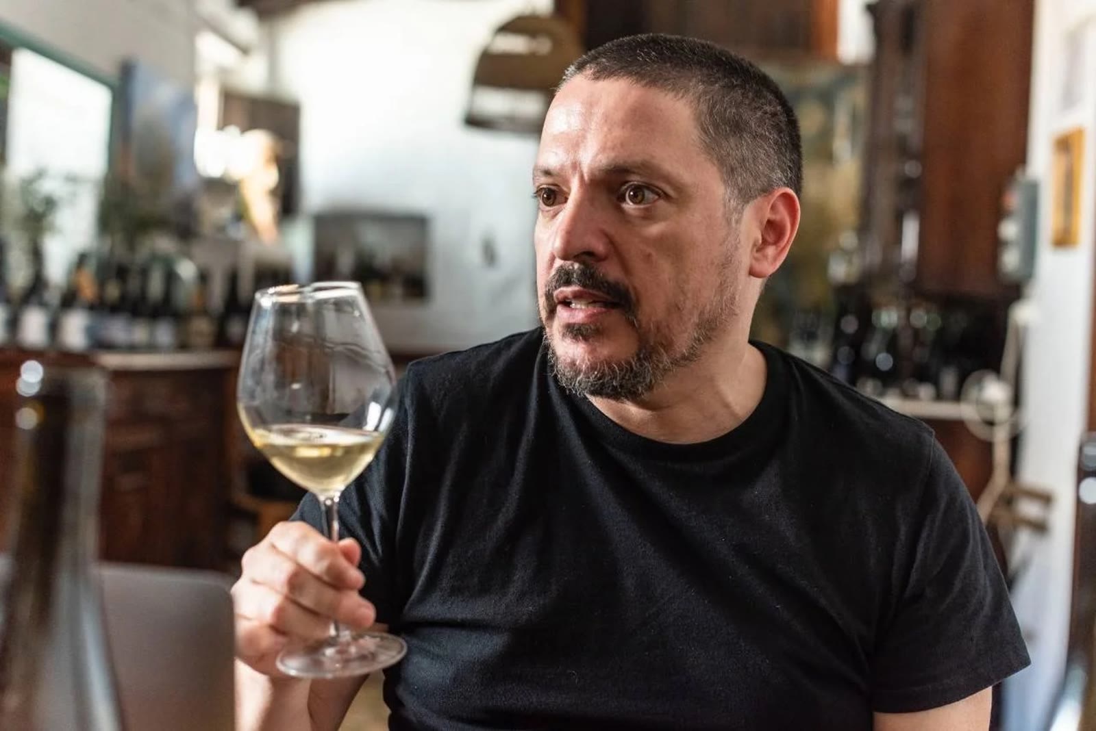 En The Net Zero Wine Bar, copa de blanco en mano